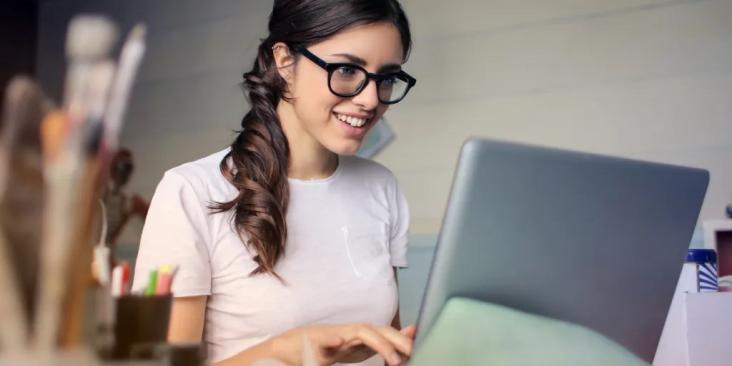 Young woman looking excitedly at her laptop screen