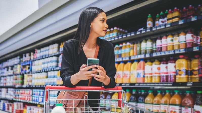 Woman with shopping cart in an aisle at the grocery store